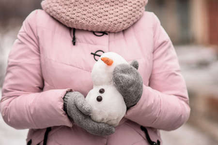 a small snowman made of snow in the handsの写真素材