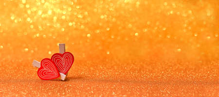 Two small wooden hearts on bright golden lights bokeh background Valentines day cardの写真素材