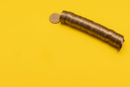coins folded. roll out metal ukrainian hryvnia lying on the yellow background. mock up