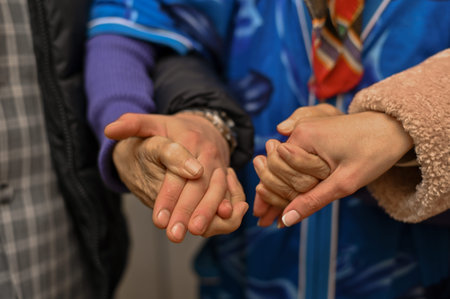 the grandmother holds the hands of a young man and a woman. close-up. old hands.