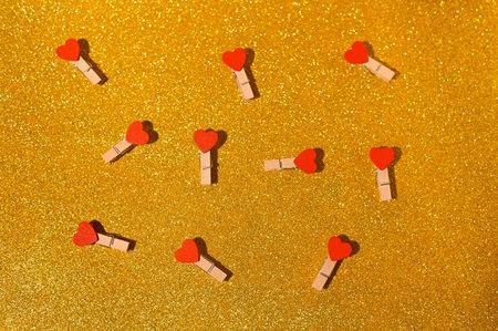 golden shiny background of hearts on clothespins