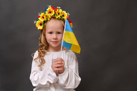 A girl with a beautiful wreath and the flag of Ukraine on a gray background. mock upの写真素材