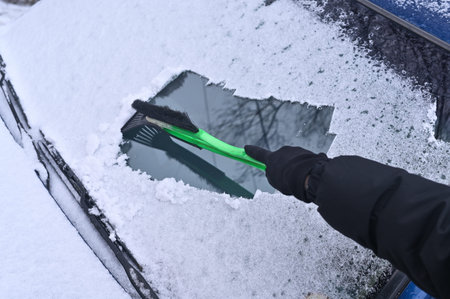 cleaning the windshield of a car in winter from ice and snow
