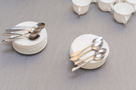 teaspoons on saucers and empty white clean cups on the tableの写真素材