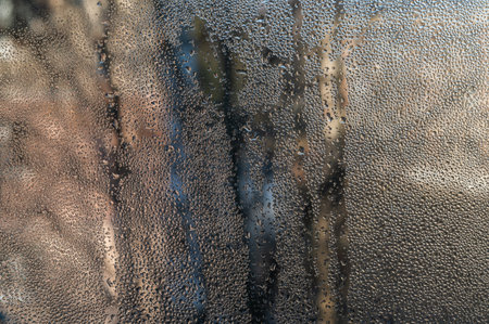 wet glass, drops on window. condensation droplets pattern interior glass like morning dew. abstract glass background. fogged window inside apartment, increased humidity, cold condensation on windowの写真素材