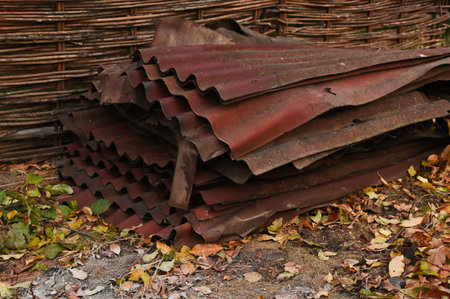 Roofing sheets stacked outdoors in yard, old roofing is out of order, worn out. roofing panels...