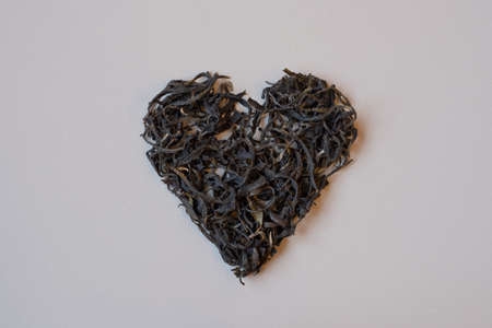 Green tea leaves in heart shape. Organic Georgian dry green tea. for making hot tea. Tea lover. Healthy beverage.の写真素材