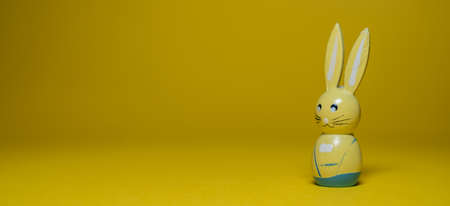 Happy Easter greeting card background with empty copy space. Cute and colorful Easter bunny rabbit over yellow background.の写真素材