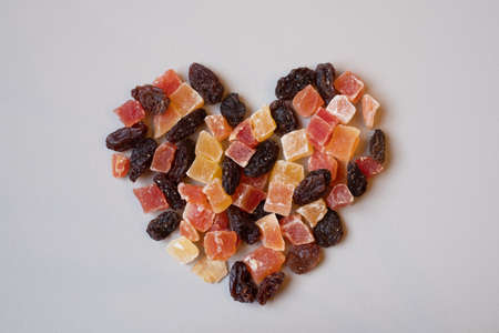 Colorful variety of dried fruit in heart shape. Love healthy eating. Healthy snack.の写真素材