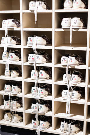 Bowling shoes rental. Different sizes of bowling shoes in a shelf in a bowling clubの写真素材