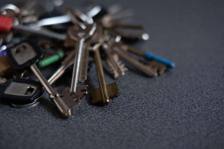 Large pile of different keys on gray background. Collection of variuos keysの写真素材