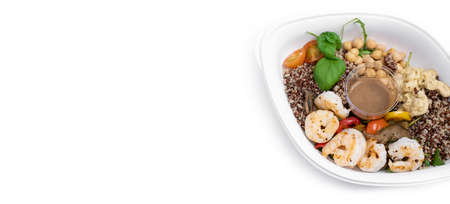 Healthy and delicious take-away shrimp salad in white plastic container. Salad with king prawns, warm grilled vegetables, quinoa, chickpeas, tomatoes and hummus. Take-out food. Balanced lunch.の写真素材