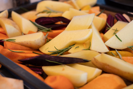 Freshly cut and seasoned vegetables ready for oven baking. Preparing roasted vegetables on oven tray.の写真素材