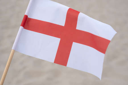 English flag waving in wind. Flag of England on sand background.の写真素材