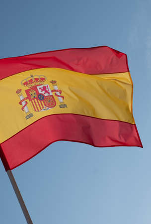 Spanish flag waving in wind. Flag of Spain on blue sky background.の写真素材