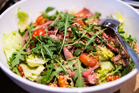 Fresh green salad with tomato. Delicious professional looking food and snacks served at catering event or party buffet style.の写真素材
