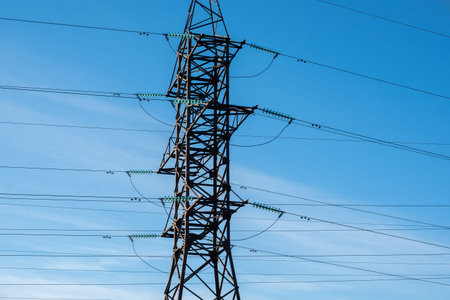 Electrical power grid and blue sky. Electric tower and lines. Energy supply. High electricity...