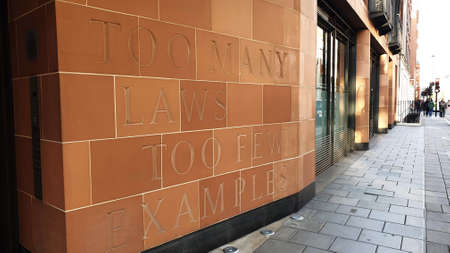 London, UK - 01.18.2020: Close-up of a building wall in London, 21 Davies Street with verse carved into the terracotta facade  "Too Many Laws Too Few Examples"のeditorial素材