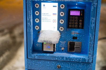 Tallinn, Estonia - 01.30.2022: Self service payment maschine during cold winter storm evening.