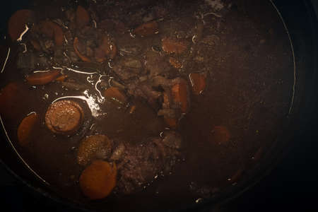 Braised beef cheeks cooking in red wine sauce in cast iron Dutch oven.の写真素材