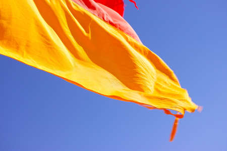 Closeup of Red and Yellow beach flag on Australian beach. Red and yellow flag. Lifeguard sign. Lifeguard flags on seashore at Coffs Harbour, Australia.の写真素材