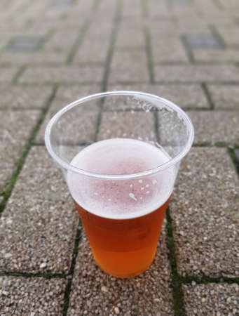 A cup of beer on a concrete surface.の写真素材