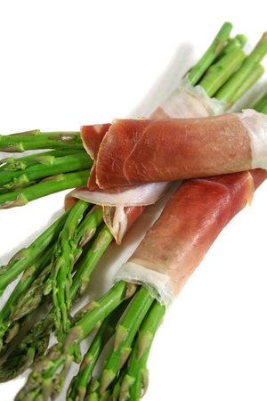 Fresh asparagus wrapped in prosciutto ready to cook.の写真素材