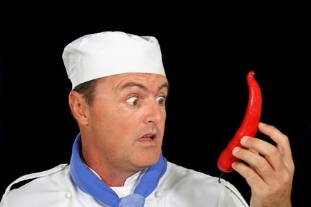 Surprised chef with a giant chili pepper.の写真素材