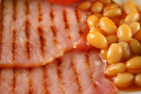 Breakfast of grilled bacon and baked beans.の写真素材