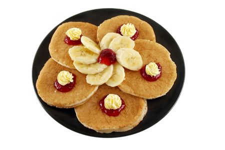 Delicious pancakes with butter swirls and strawberry jam with banana.の写真素材