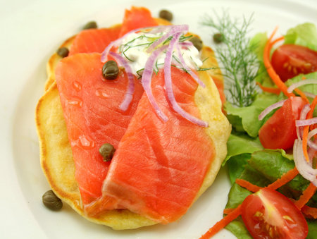 Corn fritters topped with smoked trout with dill, capers and cottage cheese.の写真素材