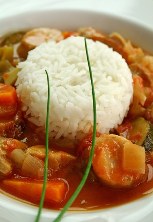 Delicious chicken gumbo with rice, sausage, peppers, onions, carrots and tomatoes.の写真素材