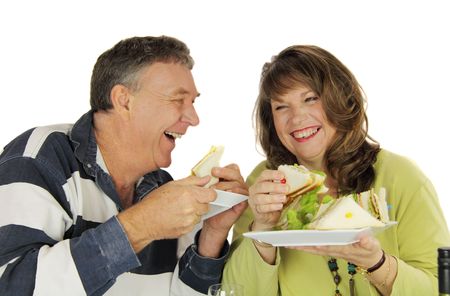 Middle aged couple laughing and enjoying lunch together.の写真素材