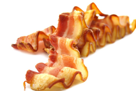 Strips of curly crispy bacon which have been baked.