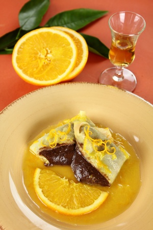 Sliced chocolate crepe suzette with orange sauce and a slice of orange.の写真素材