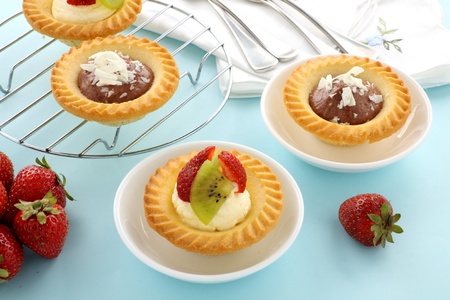Delicious and decadent cream and chocolate tarts with fresh strawberries.の写真素材