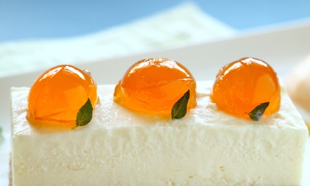 Delicious mandarin cheese cake with mandarin jelly balls and a fruit sauce.の写真素材