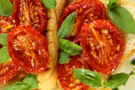 Delicious roasted cherry tomatoes with basil on bruschetta.の写真素材