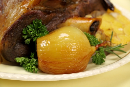 Delicious baked onion served with a leg of lamb.の写真素材
