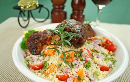 Roasted lamb shank and rosemary on tomato, butternut pumpkin and parsley couscous.の写真素材