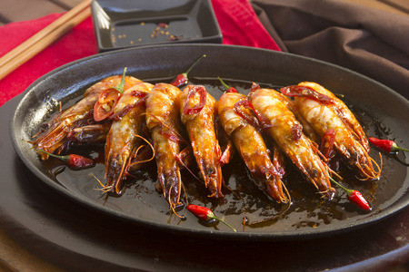 Delicious Asian sizzling chilli shrimps served in a hot cast iron platter.の写真素材