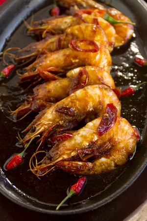 Delicious Asian sizzling chilli shrimps served in a hot cast iron platter.の写真素材