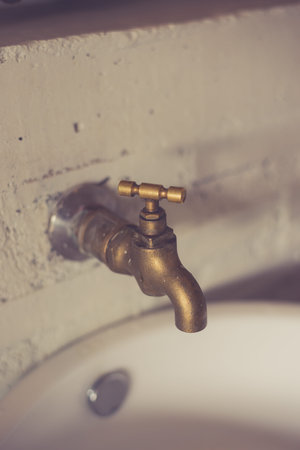 On the white wall the old brass faucet made with vintage filter.