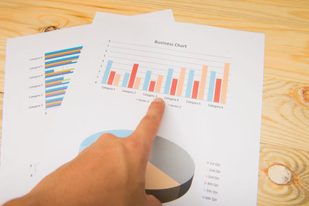 Hand pointing at a colorful chart graph