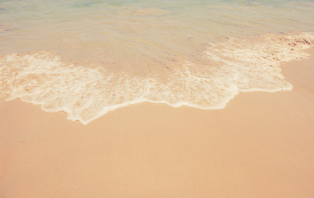 Sand beach and wave background made with vintage filter.の写真素材