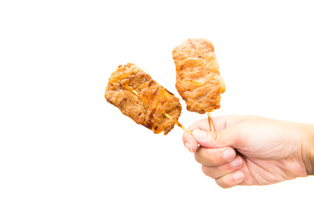 Hand hold grilled pork on white backgroundの写真素材