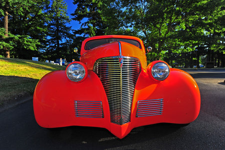 Abstract of a bright orange 1936 hot rod with bright and detailed chrome grill, bright headlights...