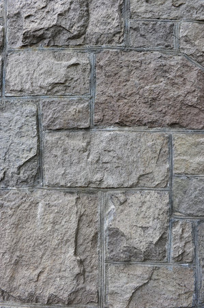 Abstract close up of an old stone wall with with detail on the surface roughness of the stones,...