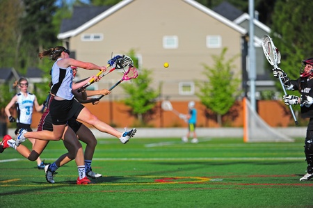 May 05, 2011 OGLA (OR Girls Lacrosse) Hillsboro OR Century HS Jags Var V Sherwood HS Bowmen.  Final 2011 league game, Jag #2 Mareen Dunlop comes down from her leaping shot at goal as the ball sails into the goal past the goalies block. Score 18-12  Jagsのeditorial素材