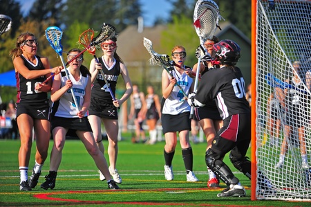 May 05, 2011 OGLA (Oregon Girls Lacrosse) Hillsboro OR Century HS Jags Var V Sherwood HS Bowmen. Bowmen #4 and 18 cross sticks in front of Jag #9 Clarissa Boggs stopping her right on the crease in front of the goal.  Final score 18-12 Centuryのeditorial素材
